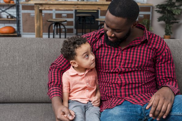 black dad talking to kid comforting