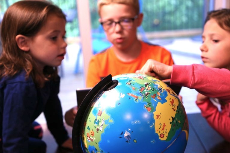 three kids around orboot globe learning