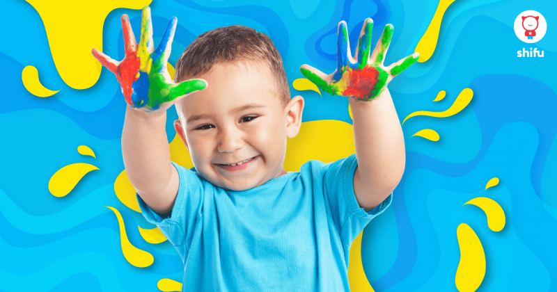 kid with painted hands smiling at camera